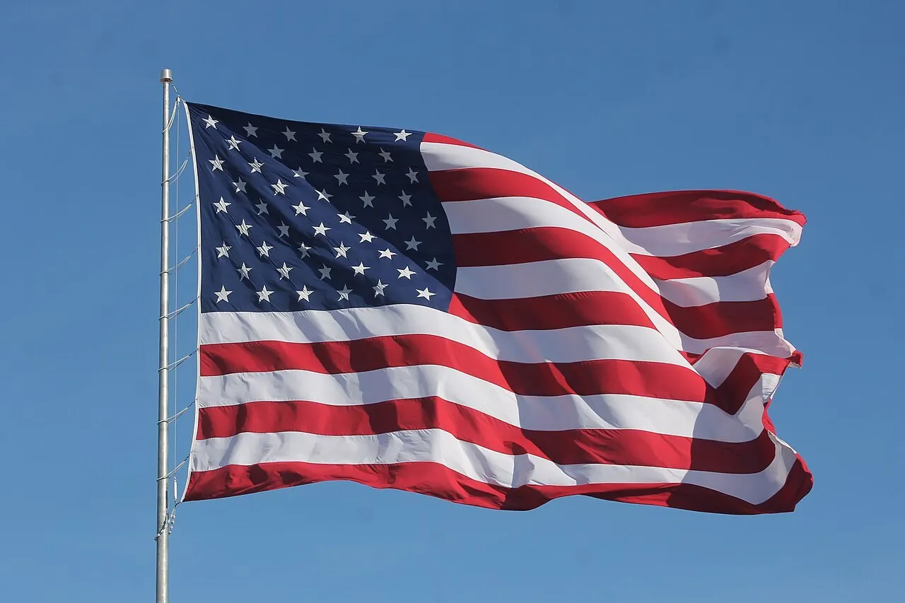 An American flag waving against a clear blue sky.